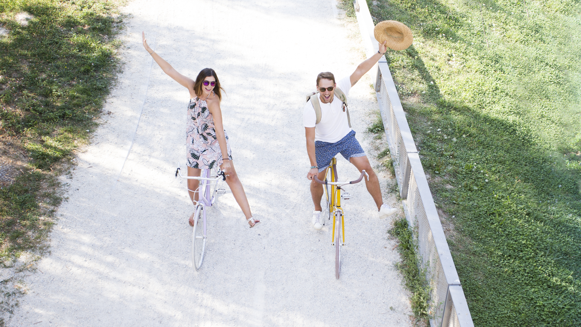 A spontaneous romantic tourist couple riding a bike on a cycle lane.